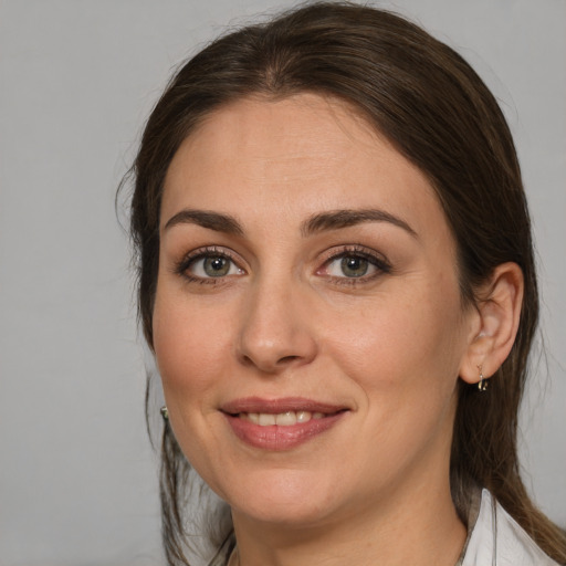 Joyful white young-adult female with medium  brown hair and blue eyes