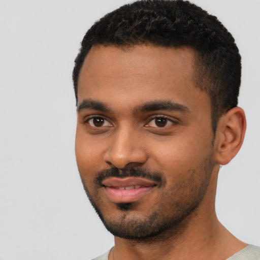 Joyful black young-adult male with short  black hair and brown eyes