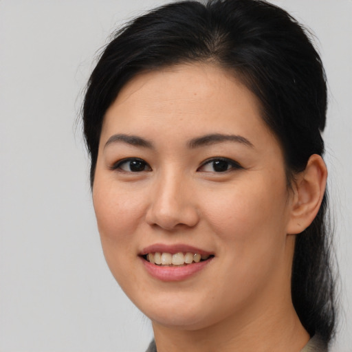 Joyful asian young-adult female with long  brown hair and brown eyes