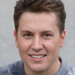 Joyful white adult male with short  brown hair and grey eyes