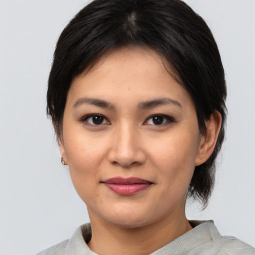 Joyful asian young-adult female with medium  brown hair and brown eyes