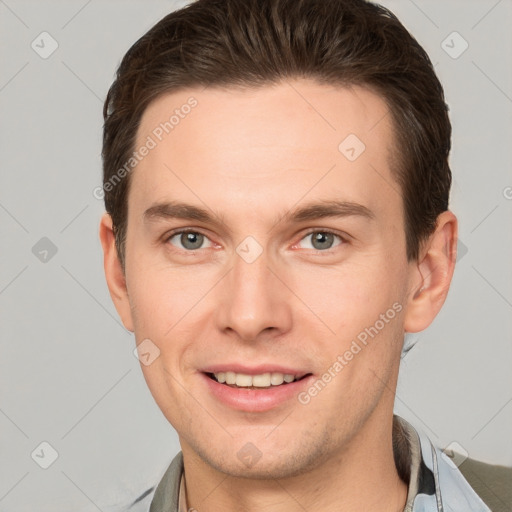 Joyful white young-adult male with short  brown hair and grey eyes