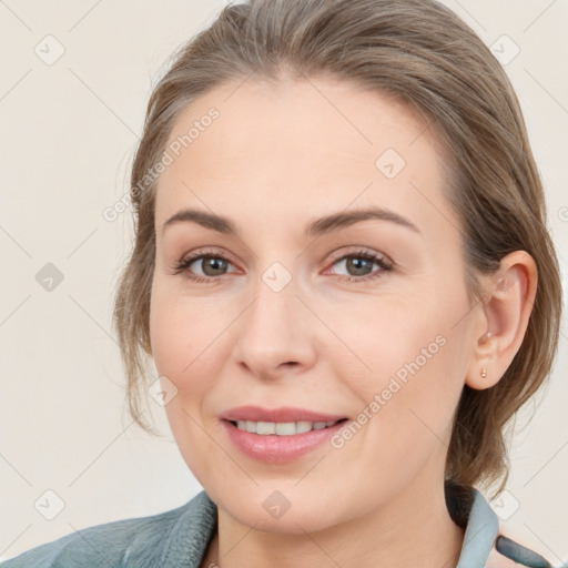 Joyful white young-adult female with medium  brown hair and blue eyes