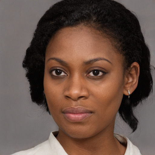 Joyful black young-adult female with medium  black hair and brown eyes