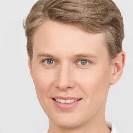 Joyful white young-adult male with short  brown hair and grey eyes