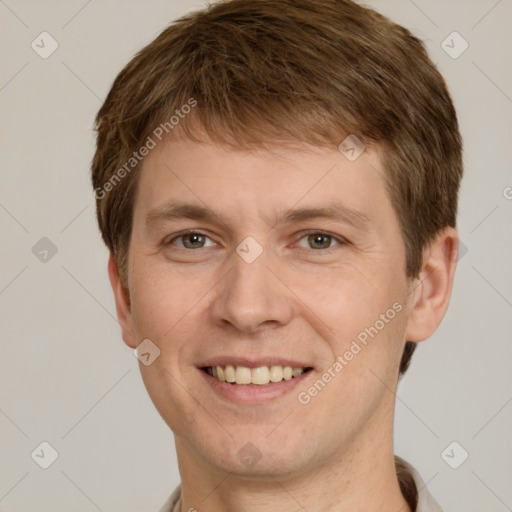 Joyful white young-adult male with short  brown hair and grey eyes