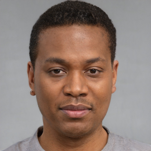 Joyful latino young-adult male with short  brown hair and brown eyes