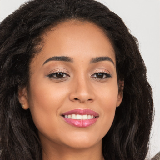 Joyful latino young-adult female with long  brown hair and brown eyes