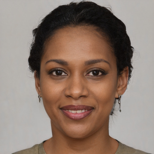 Joyful black young-adult female with short  black hair and brown eyes