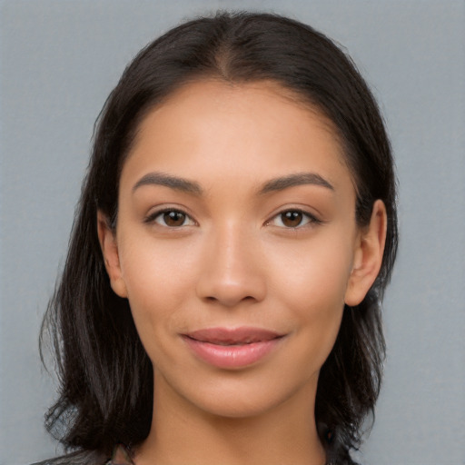 Joyful latino young-adult female with long  brown hair and brown eyes