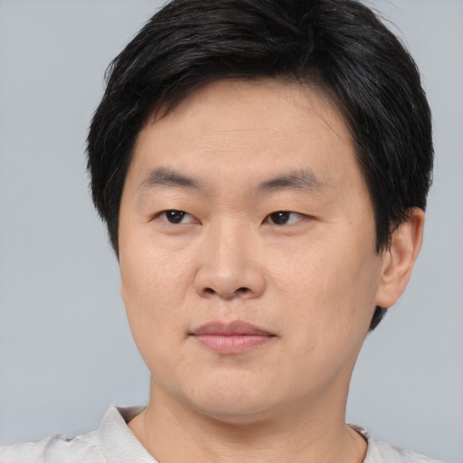 Joyful asian young-adult male with short  black hair and brown eyes