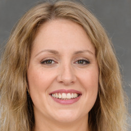 Joyful white adult female with long  brown hair and brown eyes