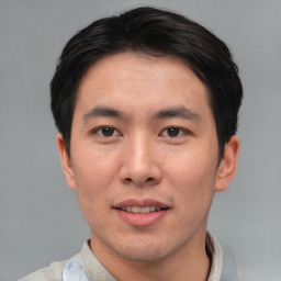 Joyful asian young-adult male with short  brown hair and brown eyes