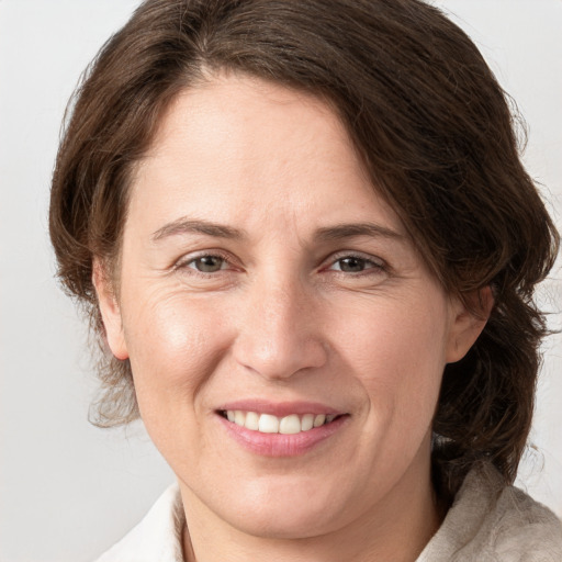 Joyful white adult female with medium  brown hair and grey eyes