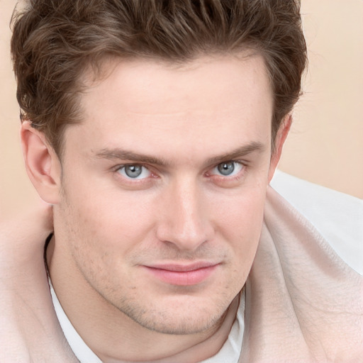 Joyful white young-adult male with short  brown hair and blue eyes