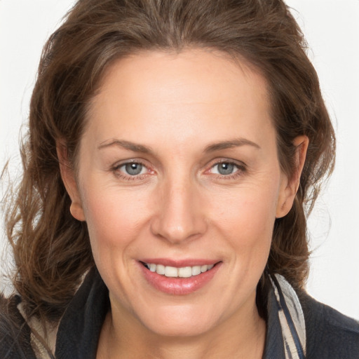 Joyful white adult female with long  brown hair and grey eyes