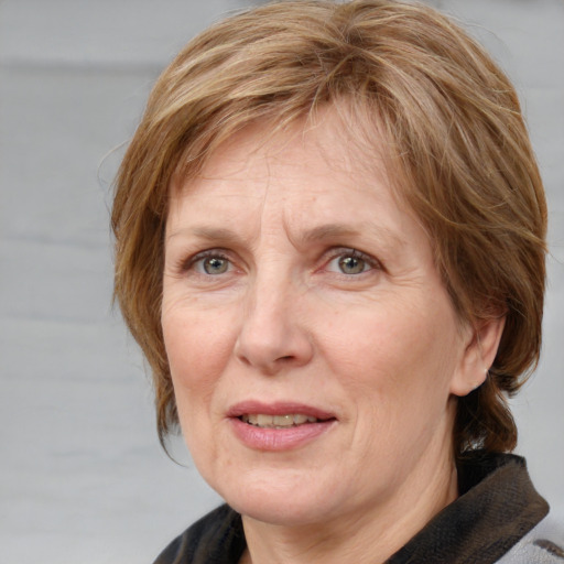 Joyful white middle-aged female with medium  brown hair and blue eyes