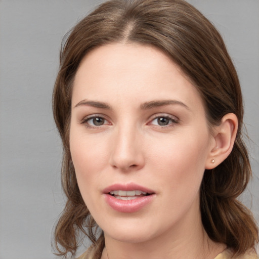 Joyful white young-adult female with medium  brown hair and grey eyes