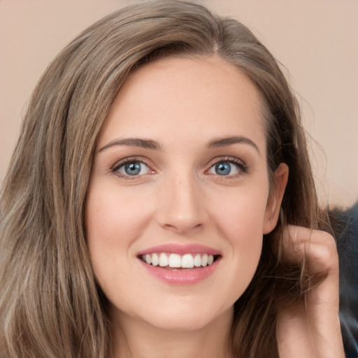 Joyful white young-adult female with long  brown hair and green eyes