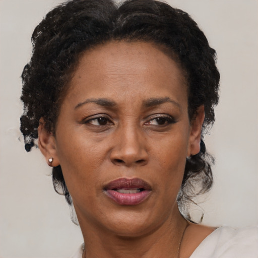 Joyful black adult female with short  brown hair and brown eyes