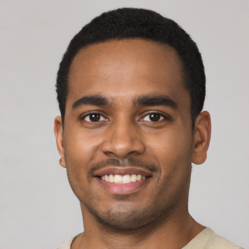 Joyful black young-adult male with short  black hair and brown eyes