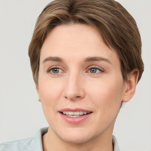 Joyful white young-adult female with short  brown hair and grey eyes