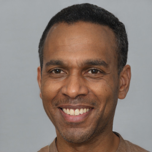 Joyful latino adult male with short  black hair and brown eyes