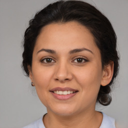 Joyful latino adult female with medium  brown hair and brown eyes