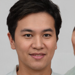 Joyful asian young-adult male with short  brown hair and brown eyes