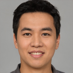 Joyful asian young-adult male with short  black hair and brown eyes