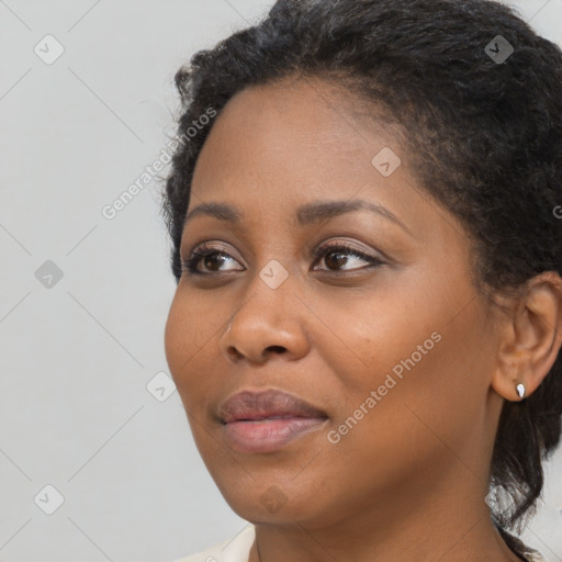 Joyful black young-adult female with long  black hair and brown eyes