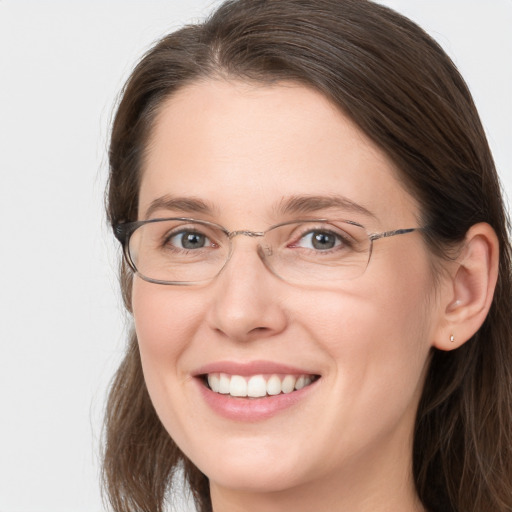 Joyful white adult female with long  brown hair and grey eyes