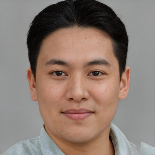 Joyful asian young-adult male with short  brown hair and brown eyes