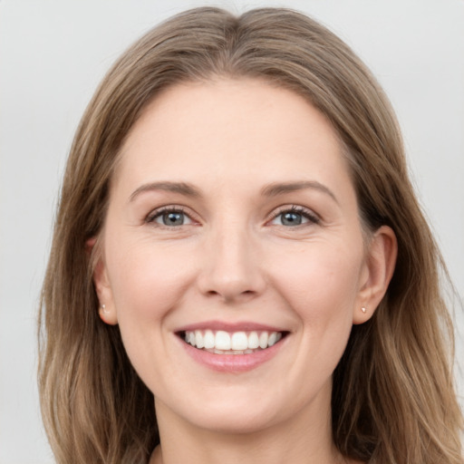 Joyful white young-adult female with long  brown hair and grey eyes