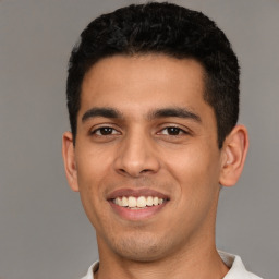 Joyful latino young-adult male with short  black hair and brown eyes