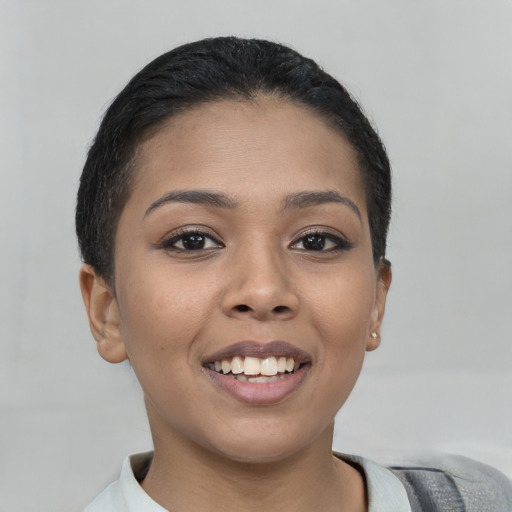 Joyful latino young-adult female with short  brown hair and brown eyes