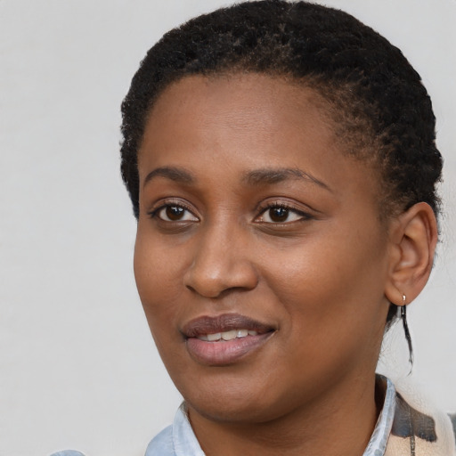 Joyful black young-adult female with short  black hair and brown eyes