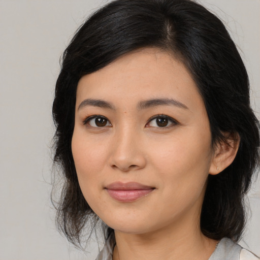 Joyful asian young-adult female with medium  black hair and brown eyes