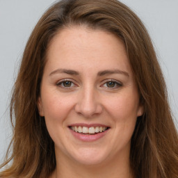 Joyful white young-adult female with long  brown hair and green eyes