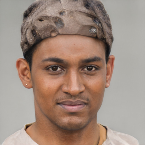 Joyful black young-adult male with short  brown hair and brown eyes