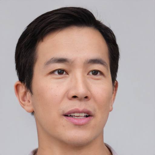 Joyful asian young-adult male with short  brown hair and brown eyes