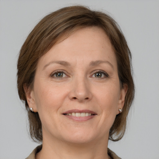 Joyful white adult female with medium  brown hair and grey eyes