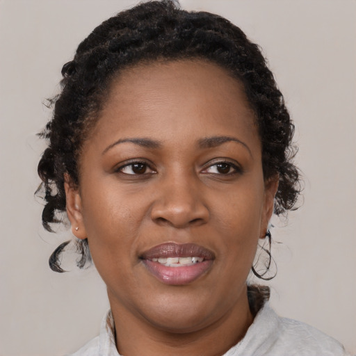 Joyful black adult female with medium  brown hair and brown eyes