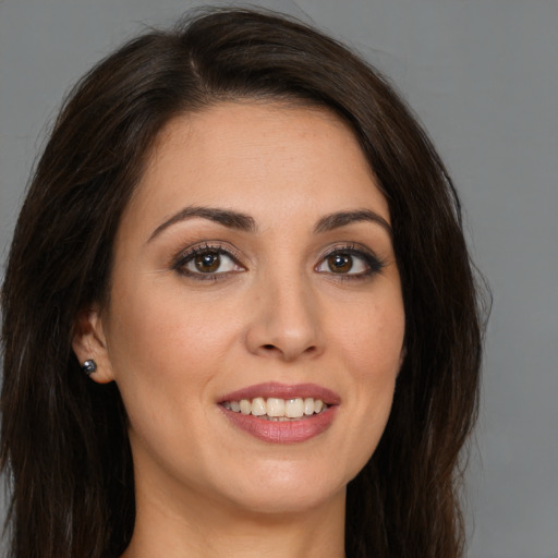 Joyful white young-adult female with long  brown hair and brown eyes