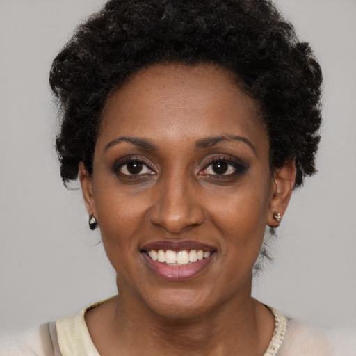 Joyful black young-adult female with short  black hair and brown eyes