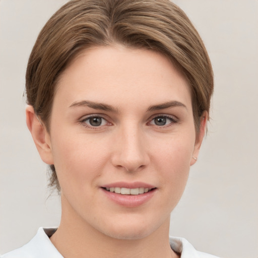 Joyful white young-adult female with short  brown hair and grey eyes