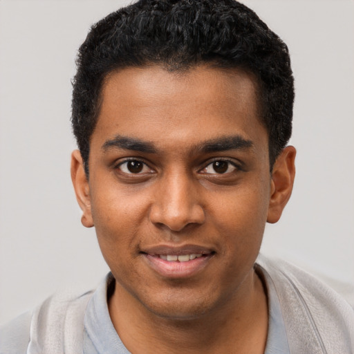 Joyful black young-adult male with short  black hair and brown eyes