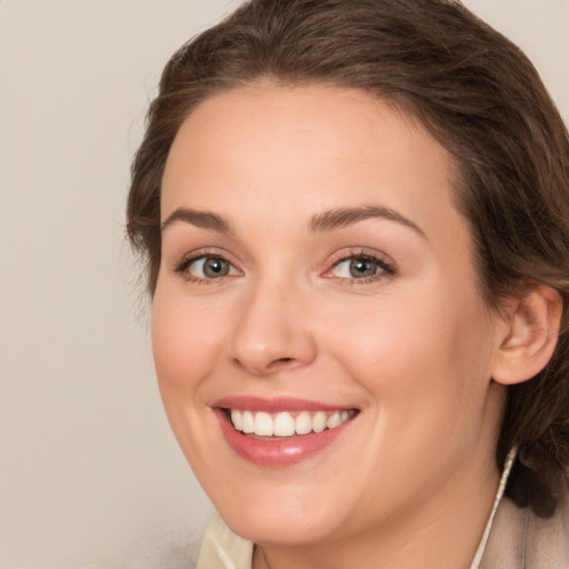 Joyful white young-adult female with medium  brown hair and green eyes