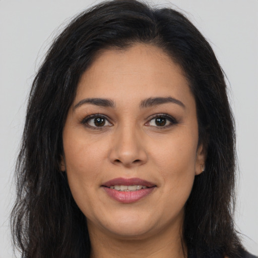 Joyful latino young-adult female with long  brown hair and brown eyes