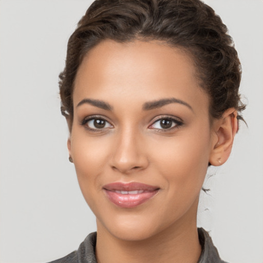 Joyful latino young-adult female with long  brown hair and brown eyes